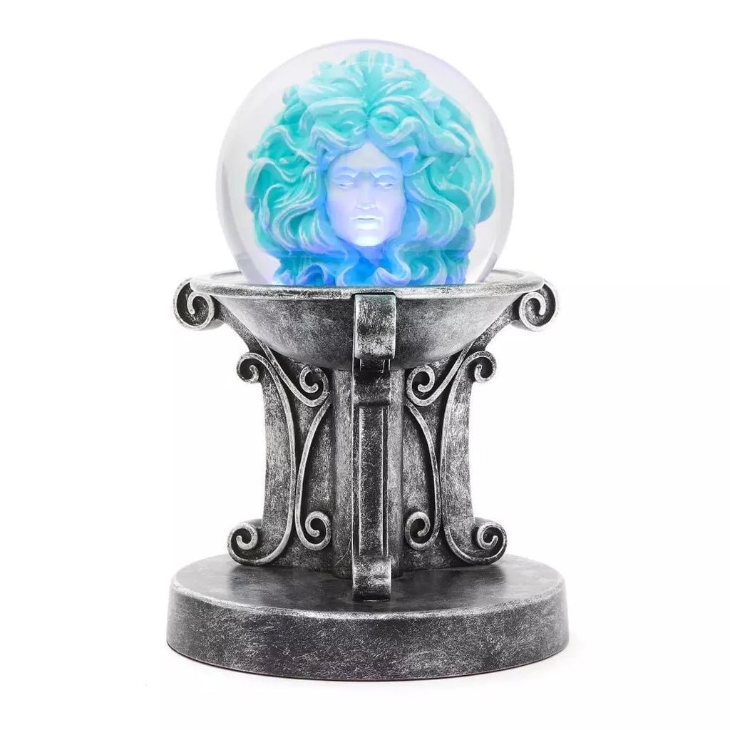 Glowing crystal ball with a face design on an ornate stand against a white background
