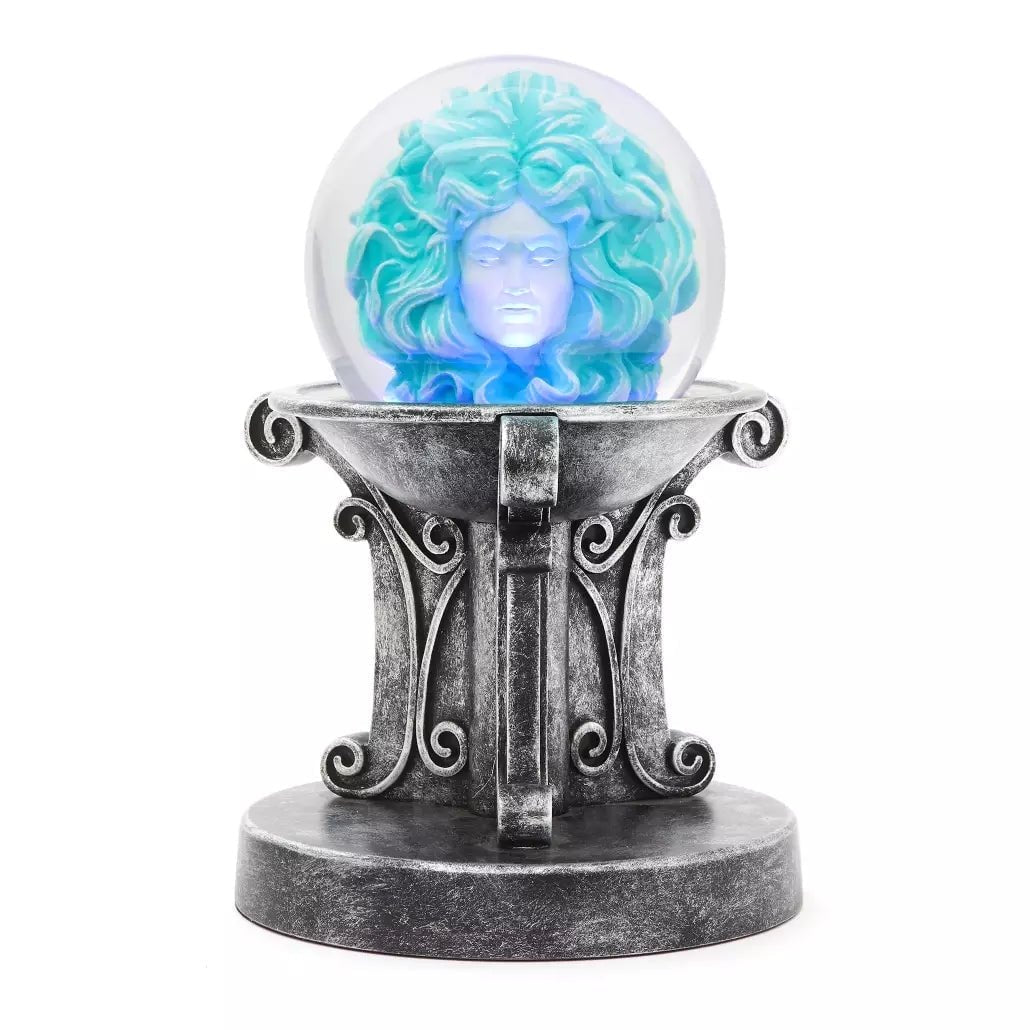 Glowing crystal ball with a face design on an ornate stand against a white background